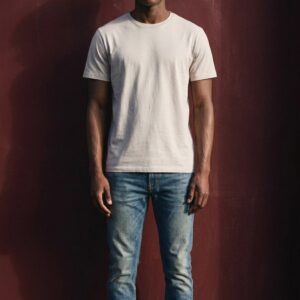 Homme portant un jean slim délavé bleu et un t-shirt beige